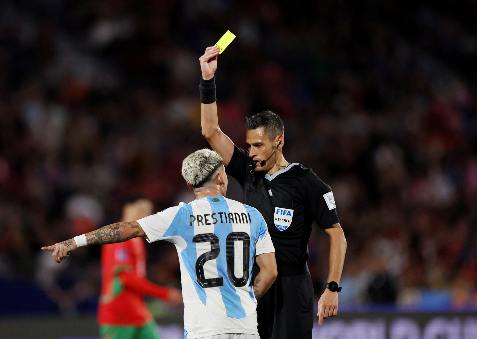 El argentino Gianluca Prestianni recibe una tarjeta amarilla del árbitro Maurizio Mariani 