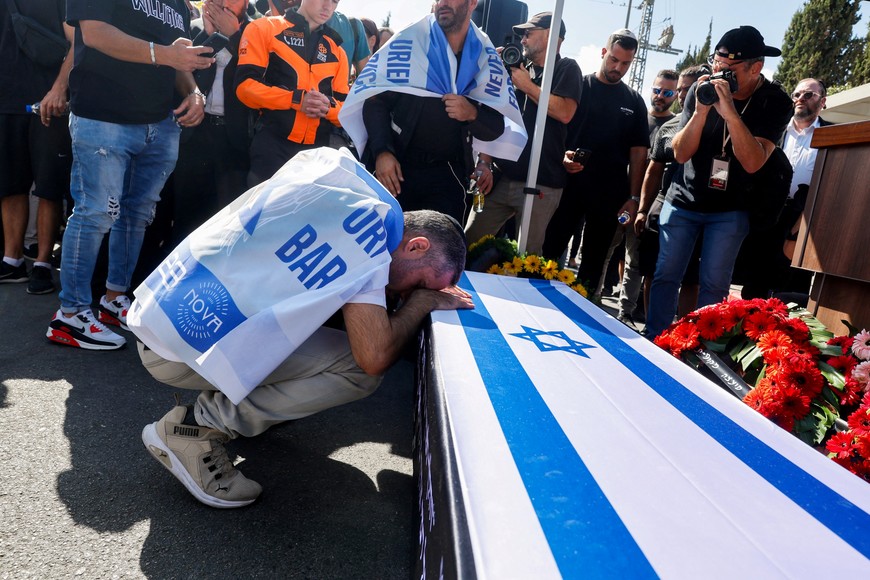 Idan, brother of Israeli hostage Uriel Baruch, who according to the Israeli army was killed during the deadly October 7, 2023 attack on Israel by Hamas, after attending the Nova festival, and whose body was taken into the Gaza Strip, grieves on his casket, during his funeral in Jerusalem, October 19, 2025. REUTERS/Oren Ben Hakoon    ISRAEL OUT. NO COMMERCIAL OR EDITORIAL SALES IN ISRAEL
