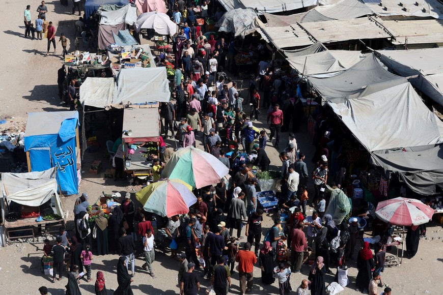 Palestinians shop at a market, amid a ceasefire between Israel and Hamas, in Khan Younis, southern Gaza Strip, October 20, 2025. REUTERS/Ramadan Abed
