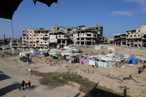 Displaced Palestinians live in tents near destroyed buildings as they cannot return to their houses, amid a ceasefire between Israel and Hamas, in Gaza City, October 19, 2025. REUTERS/Ebrahim Hajjaj
