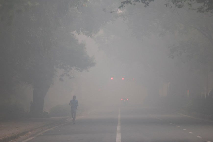 A man jogs on a road shrouded in smog on the day after Diwali, the Hindu festival of lights, in New Delhi, India, October 21, 2025. REUTERS/Bhawika Chhabra