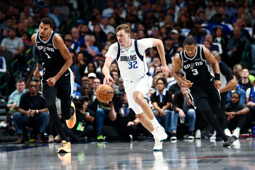 Oct 22, 2025; Dallas, Texas, USA;  Dallas Mavericks forward Cooper Flagg (32) dribbles the ball as San Antonio Spurs forward Victor Wembanyama (1) and San Antonio Spurs forward Keldon Johnson (3) chase during the first half  at American Airlines Center. Mandatory Credit: Kevin Jairaj-Imagn Images