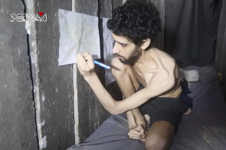 En cautiverio. Esta imagen, tomada de un video difundido el 1 de agosto de 2025 por el brazo armado de Hamás, muestra al rehén israelí Evyatar David mientras anota su registro de alimentos en un calendario dentro de un túnel bajo Gaza.