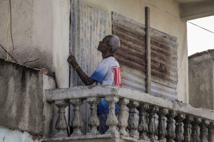 Un hombre cubre las ventanas de su casa con chapas antes de la llegada del huracán Melissa a Cuba.