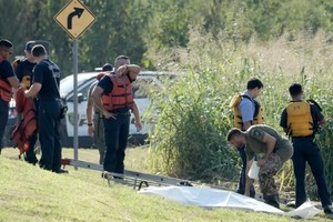 Bomberos y policías de Houston recuperando un cuerpo del pantano White Oak.