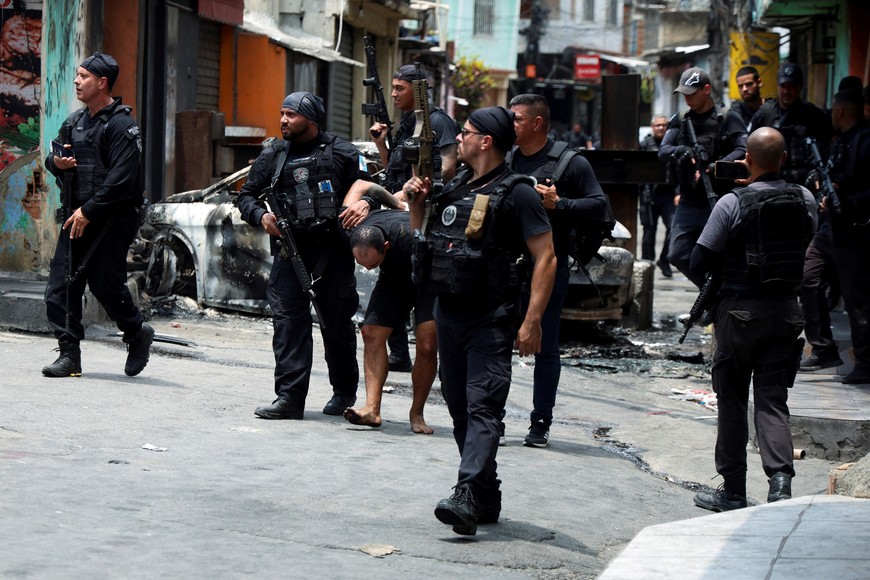 A man is detained by police officers during a police operation against drug trafficking at the favela do Penha, in Rio de Janeiro, Brazil October 28, 2025. REUTERS/Aline Massuca
