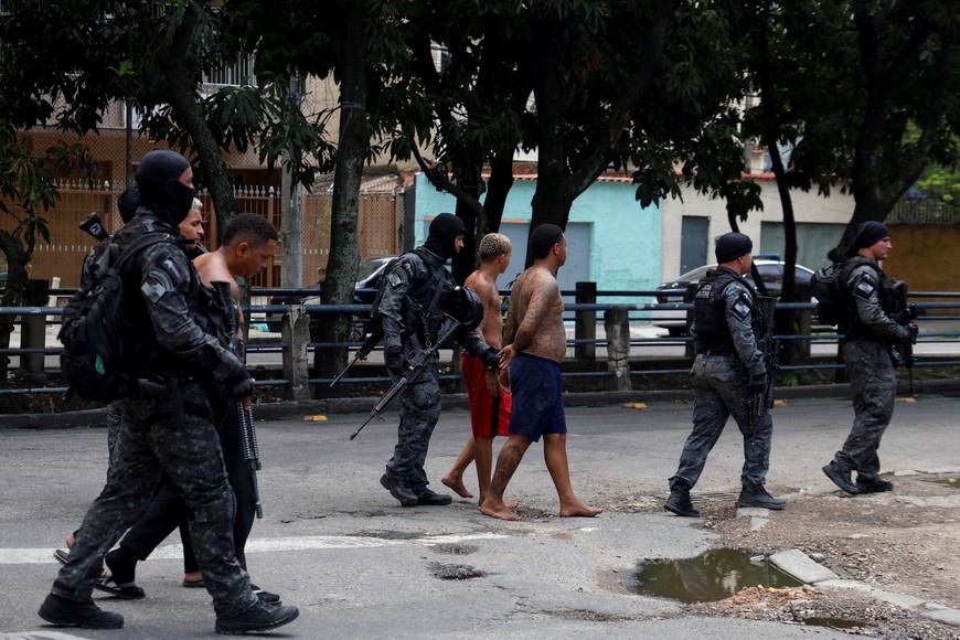 Members of the military police special unit detain suspected drug dealers during a police operation against drug trafficking at the favela do Penha, in Rio de Janeiro, Brazil October 28, 2025. REUTERS/Aline Massuca