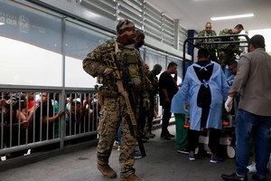 People watch as members of the military police bring bodies of dead people to a hospital, on the day of a police operation against drug trafficking at the favela do Penha, in Rio de Janeiro, Brazil October 28, 2025. REUTERS/Aline Massuca