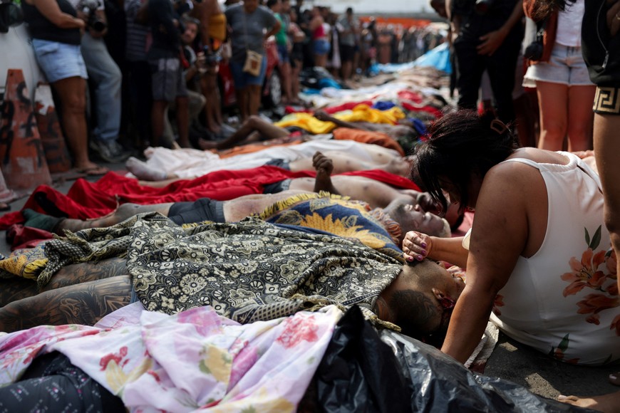 SENSITIVE MATERIAL. THIS IMAGE MAY OFFEND OR DISTURB A mourner leans over a body, the day after a deadly police operation against drug trafficking at the favela do Penha, in Rio de Janeiro, Brazil, October 29, 2025. REUTERS/Ricardo Moraes