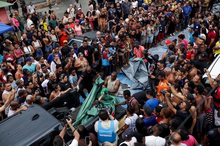 SENSITIVE MATERIAL. THIS IMAGE MAY OFFEND OR DISTURB A man takes out a body from a vehicle, the day after a deadly police operation against drug trafficking at the favela do Penha, in Rio de Janeiro, Brazil, October 29, 2025. REUTERS/Ricardo Moraes     TPX IMAGES OF THE DAY