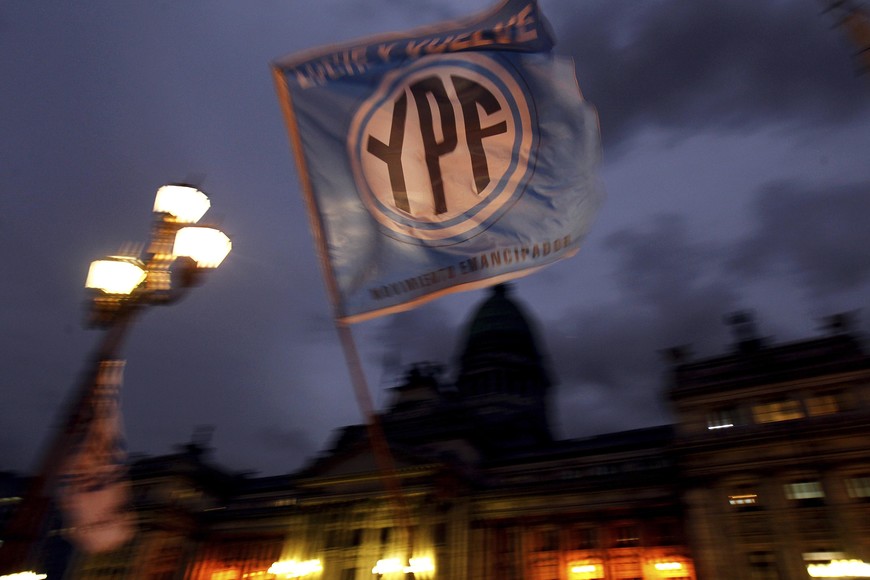 flag with the YPF logo is waved in front of the Argentine Congress in Buenos Aires, April 25, 2012. Argentina's Senate was set to approve the expropriation of the country's biggest oil company on Wednesday, underscoring broad domestic support for a move that has nonetheless sparked outrage among foreign investors. President Cristina Fernandez, who controls both houses of Congress, unveiled plans last week to seize a 51 percent stake of YPF from Spain's Repsol.  REUTERS/Marcos Brindicci (ARGENTINA - Tags: BUSINESS LOGO POLITICS ENERGY) buenos aires  debate camara alta senadores senado nacional expropiacion el 51 por ciento de las acciones de la petrolera YPF carteles manifestantes apoyo nacionalizacion