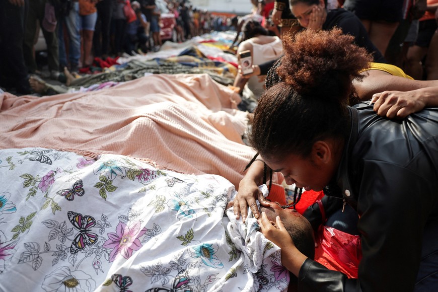 SENSITIVE MATERIAL. THIS IMAGE MAY OFFEND OR DISTURB A mourner leans over a body, the day after a deadly police operation against drug trafficking at the favela do Penha, in Rio de Janeiro, Brazil, October 29, 2025. REUTERS/Ricardo Moraes