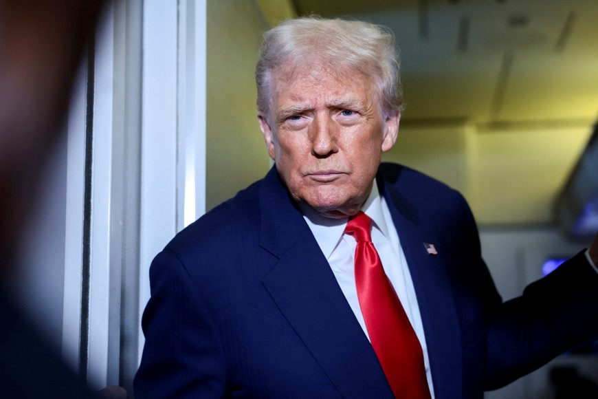 U.S. President Donald Trump speaks to members of the media on board Air Force One en route to the U.S., October 30, 2025. REUTERS/Evelyn Hockstein