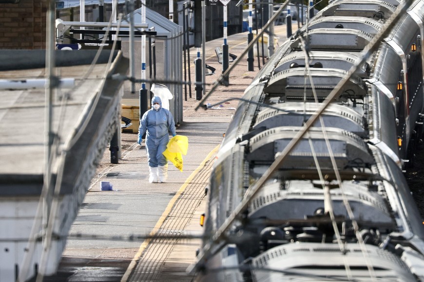A forensic officer walks next to the London North Eastern Railway (LNER) train where a series of stabbings took place, at a platform at Huntingdon Station, near Cambridge, Britain, November 2, 2025. REUTERS/Jack Taylor