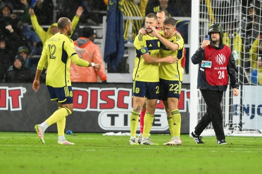 Nov 1, 2025; Nashville, Tennessee, USA;  Nashville SC defender Walker Zimmerman (25) and defender Josh Bauer (22) celebrate the win during the second half at Geodis Park. Mandatory Credit: Steve Roberts-Imagn Images