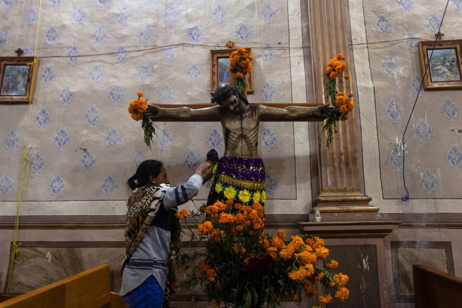 Una mujer decora el cristo de la Iglesia de Nuestra Dama de la Natividad en Arocutin.