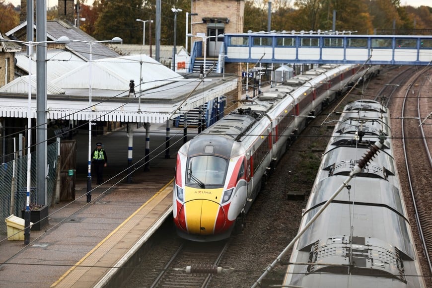 A police officer walks near the London North Eastern Railway train where a series of stabbings took place, at a platform at Huntingdon Station, near Cambridge, Britain, November 2, 2025. REUTERS/Jack Taylor