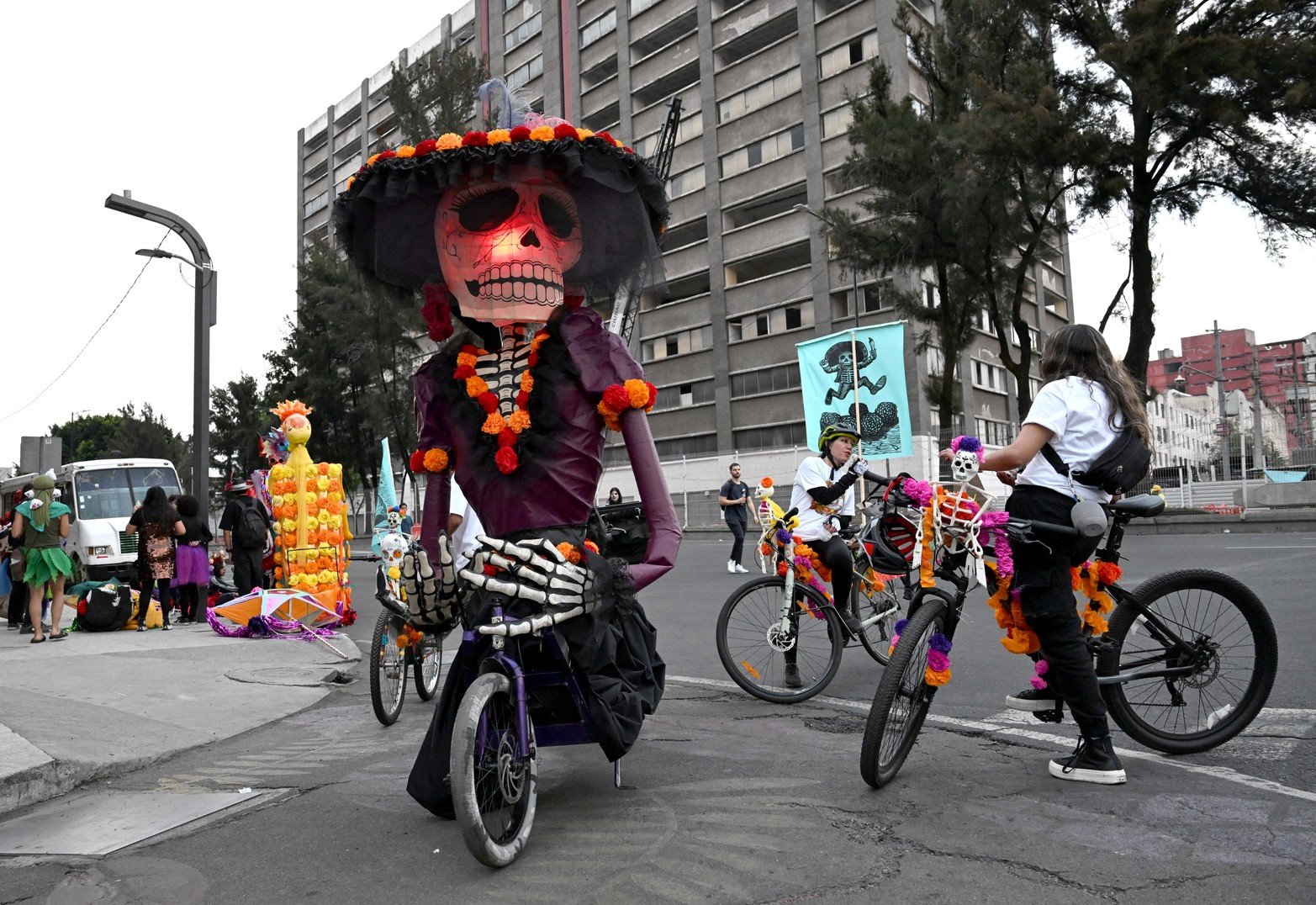 Participantes descansando en la calle después del Desfile del Día de Muertos, en el centro de la Ciudad de México.