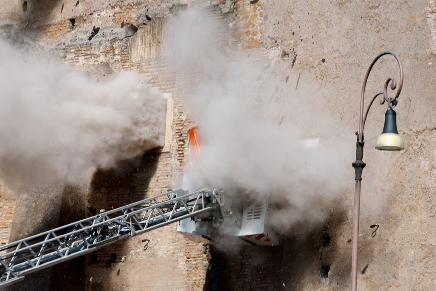 Dust rises as part of the Torre dei Conti tower collapses while members of emergency services work following an earlier partial collapse, near Via dei Fori Imperiali, near the Colosseum, in Rome, Italy, November 3, 2025. REUTERS/Remo Casilli     TPX IMAGES OF THE DAY