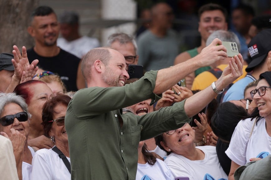 Britain's Prince William takes photos with people on Paqueta island, during an official visit in Rio de Janeiro, Brazil, November 4, 2025. REUTERS/Ricardo Moraes