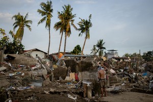 A man takes a bath amid the remains of a community where houses were swept in the floods brought on by Typhoon Kalmaegi in Talisay, Cebu, Philippines, November 6, 2025. REUTERS/Eloisa Lopez