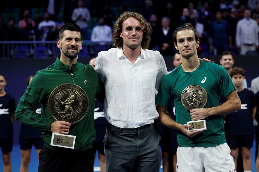 Tennis - ATP 250 - Hellenic Championship - Telekom Center Athens, Marousi, Greece - November 8, 2025
Serbia's Novak Djokovic poses with the trophy after winning the final match, alongside runner up Italy's Lorenzo Musetti and Stefanos Tsitsipas REUTERS/Louiza Vradi