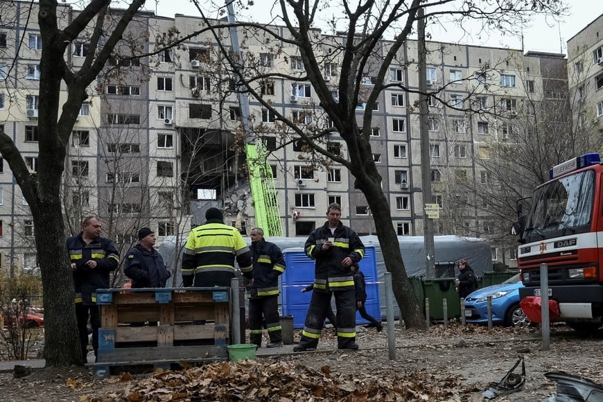 Rescuers rest after working at the site of a Russian drone strike on an apartment building, amid Russia's attack on Ukraine in Dnipro, November 8, 2025. REUTERS/Mykola Synelnykov