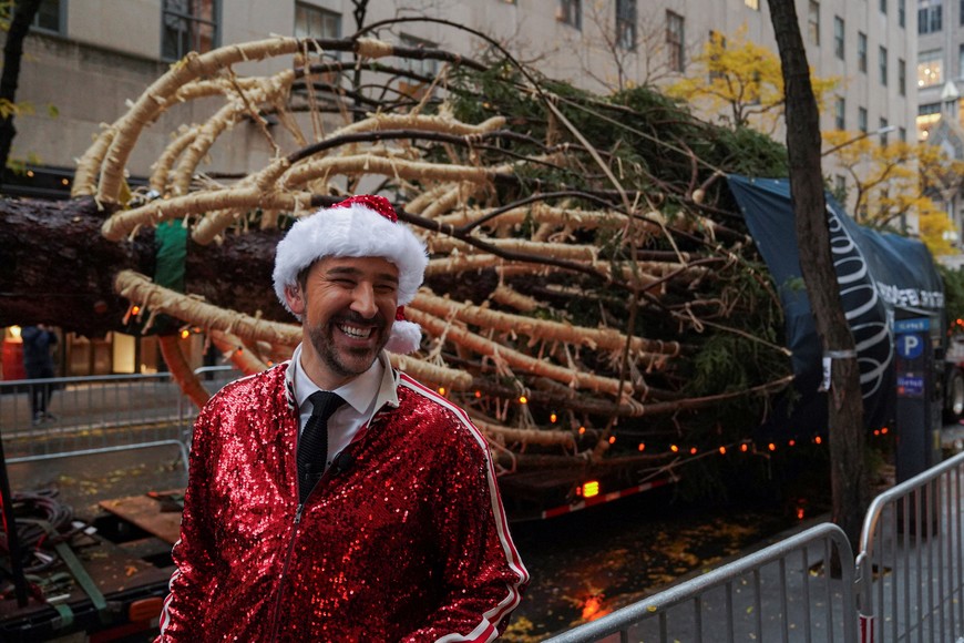 A man wearing a Santa Claus hat smiles near the 2025 Rockefeller Center Christmas Tree, a 75-foot-tall Norway Spruce, before it is installed at Center Plaza in Rockefeller Center, New York City, U.S., November 8, 2025. REUTERS/Ryan Murphy