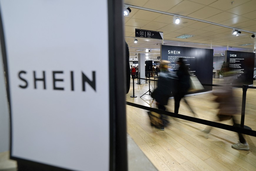 Customers walk past a Shein logo to enter the first physical space of Chinese online fast-fashion retailer Shein on the day of its opening inside the Le BHV Marais department store, the Bazar de l'Hotel de Ville, in Paris, France, November 5, 2025. REUTERS/Sarah Meyssonnier