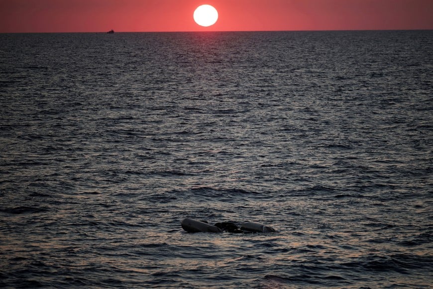 FILE PHOTO: A rubber boat used by migrants floats at the sea on sunset, as seen from the migrant search and rescue ship Sea-Watch 5, operated by German NGO Sea-Watch, in the search and rescue (SAR) zone in the central Mediterranean, off Libya, August 9, 2025. REUTERS/Louisa Gouliamaki/File Photo