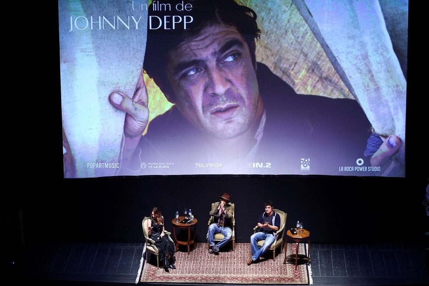 American actor and director Johnny Depp gestures next to cast member Riccardo Scamarcio and Argentine TV host Veronica Lozano, during a masterclass at Teatro Municipal Coliseo Podesta, as he presents his latest film "Modi, three days on the wing of madness", in La Plata, Argentina, November 12, 2025. REUTERS/Agustin Marcarian