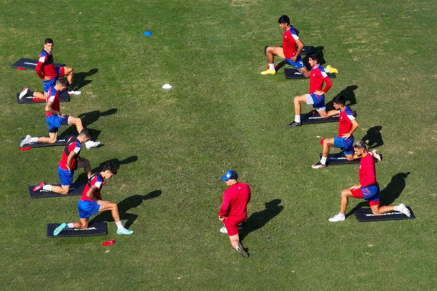 Algunos jugadores del plantel profesional tatengue elongando en el predio donde se entrenan.