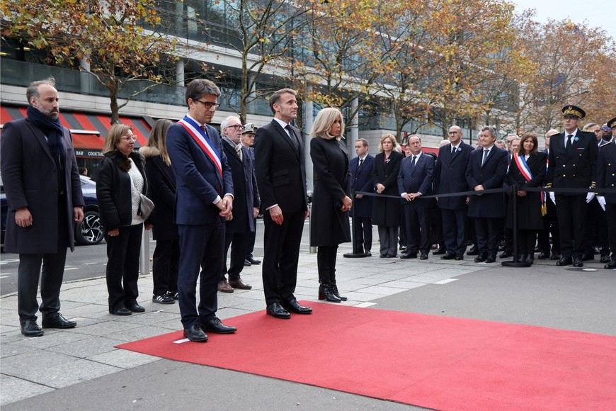 President of the Life for Paris victims association Arthur Denouveaux, Saint-Denis' mayor Mathieu Hanotin, President of France Emmanuel Macron and his wife Brigitte stand in respect during a ceremony paying tribute to victims outside the Stade de France stadium in Saint-Denis on November 13, 2025, during ceremonies across Paris marking a decade since the terror attacks of November 13, 2015 in which 130 civilians were killed.    LUDOVIC MARIN/Pool via REUTERS