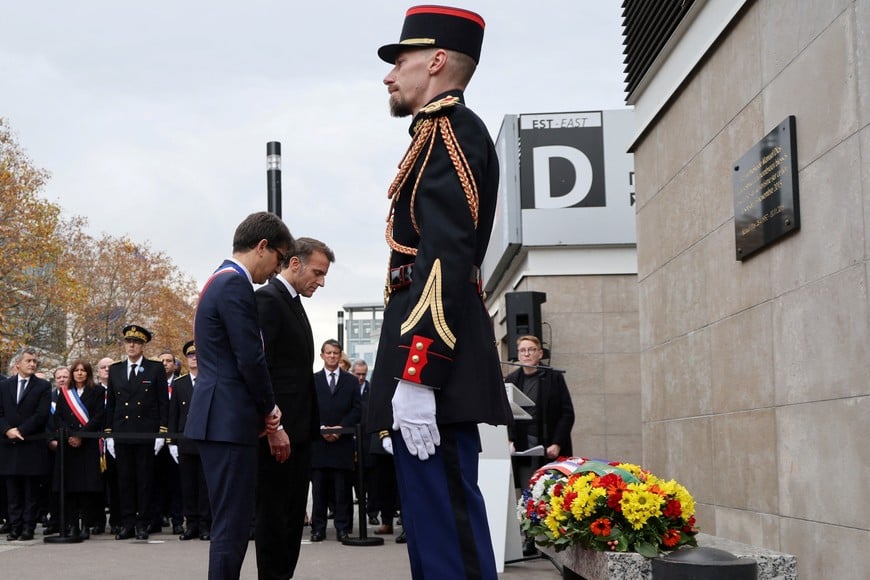 President of France Emmanuel Macron and Saint-Denis' mayor Mathieu Hanotin pay tribute to victims outside the Stade de France stadium in Saint-Denis on November 13, 2025 during ceremonies across Paris marking a decade since the terror attacks of November 13, 2015 in which 130 civilians were killed.     LUDOVIC MARIN/Pool via REUTERS