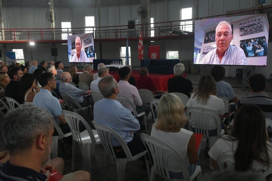 El momento en el que Nery Pumpido se dirige vía zoom a la concurrencia en el salón multipropósito de Unión.