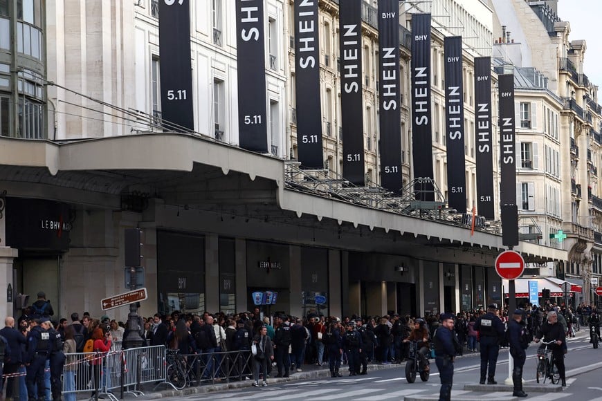FILE PHOTO: French police secure the area as people queue to enter the Le BHV Marais department store, the Bazar de l'Hotel de Ville, on the day of the opening of the first physical space for Chinese online fast-fashion retailer Shein within the Parisian department store, in Paris, France, November 5, 2025. REUTERS/Abdul Saboor/File Photo