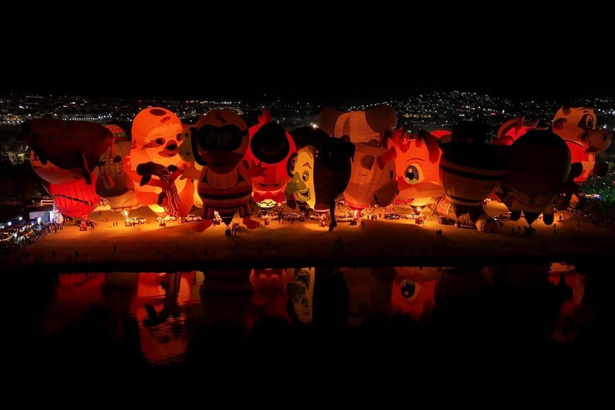 A drone view shows hot-air balloons reflected in a lake as visitors attend the International Hot Air Balloon Festival in Leon, Guanajuato state, Mexico, November 16, 2025. REUTERS/Henry Romero