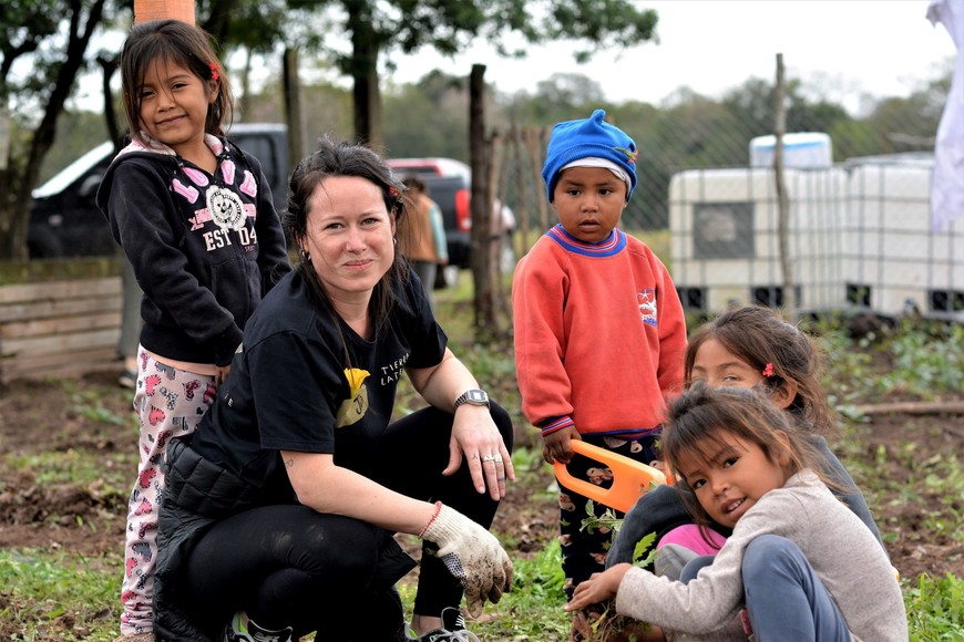 Una voluntaria con los niños chaqueños, en la huerta orgánica. Crédito: Gentileza