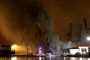 Una densa columna de humo se eleva sobre la terminal marítima.