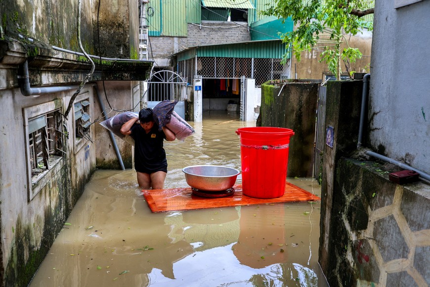A man wades through a flooded area as he carries his belongings after Typhoon Bualoi made landfall in Nghe An province, Vietnam, September 30, 2025. REUTERS/Thinh Nguyen     TPX IMAGES OF THE DAY