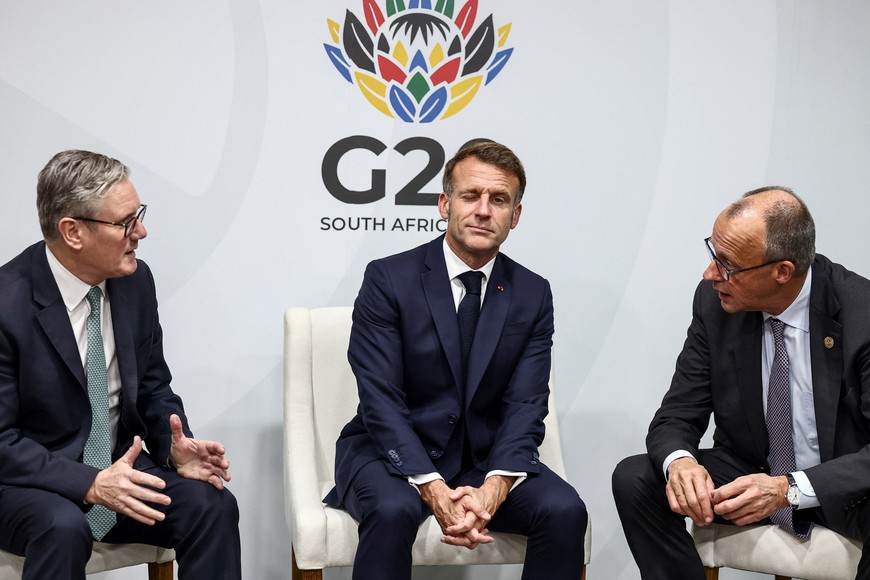 Britain's Prime Minister Keir Starmer, France’s President Emmanuel Macron and German Chancellor Friedrich Merz react as they attend a trilateral meeting at the G20 Leaders' Summit in Johannesburg, South Africa on November 22, 2025. HENRY NICHOLLS/Pool via REUTERS