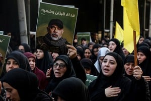 Una mujer sostiene una foto del principal oficial militar de Hezbolá, Haytham Ali Tabtabai, durante el funeral por él y otras personas que murieron en un ataque aéreo israelí el domingo, a pesar de una tregua negociada por Estados Unidos hace un año, en los suburbios del sur de Beirut, Líbano, el 24 de noviembre de 2025. REUTERS/Mohamed Azakir.