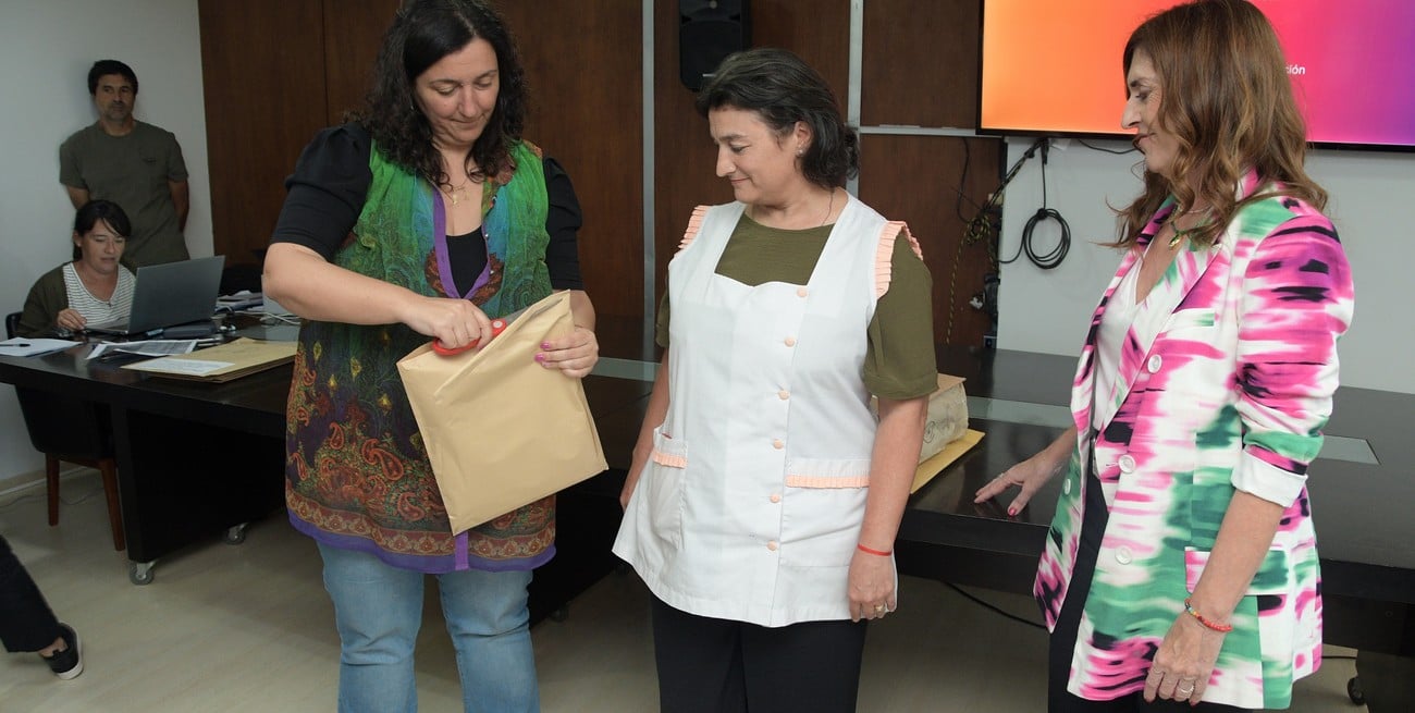 La secretaria Carolina Piedrabuena y "Chuchi" Molina abrieron una de las ofertas junto a una directora. Foto: Guillermo Di Salvatore