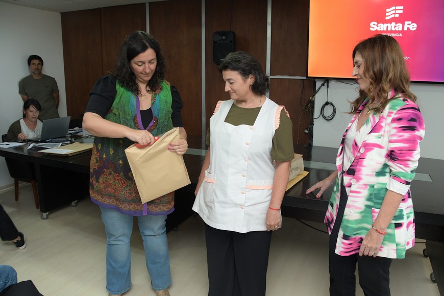 La secretaria Carolina Piedrabuena y "Chuchi" Molina abrieron una de las ofertas junto a una directora. Foto: Guillermo Di Salvatore