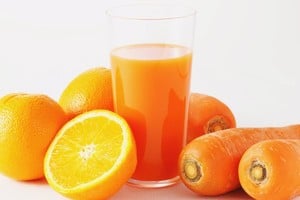 Llicuar las cáscaras de naranja y zanahoria para preparar una bebida nutritiva.