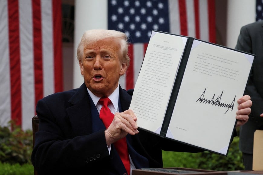 FILE PHOTO: U.S. President Donald Trump holds a signed executive order on tariffs, in the Rose Garden at the White House in Washington, D.C., U.S., April 2, 2025. REUTERS/Leah Millis/File Photo