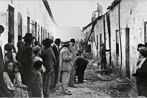 Porto, 1899. Las autoridades observan la fumigación de las casas de un barrio pobre e insalubre, la calle es de tierra, los vecinos esperan y no entienden.