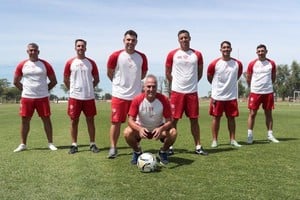 Madelón en cuclillas, Vazzoler y el Moncho Ruiz detrás suyo y, más atrás, el resto del cuerpo técnico que comenzará a trabajar el 2 de enero con el plantel.