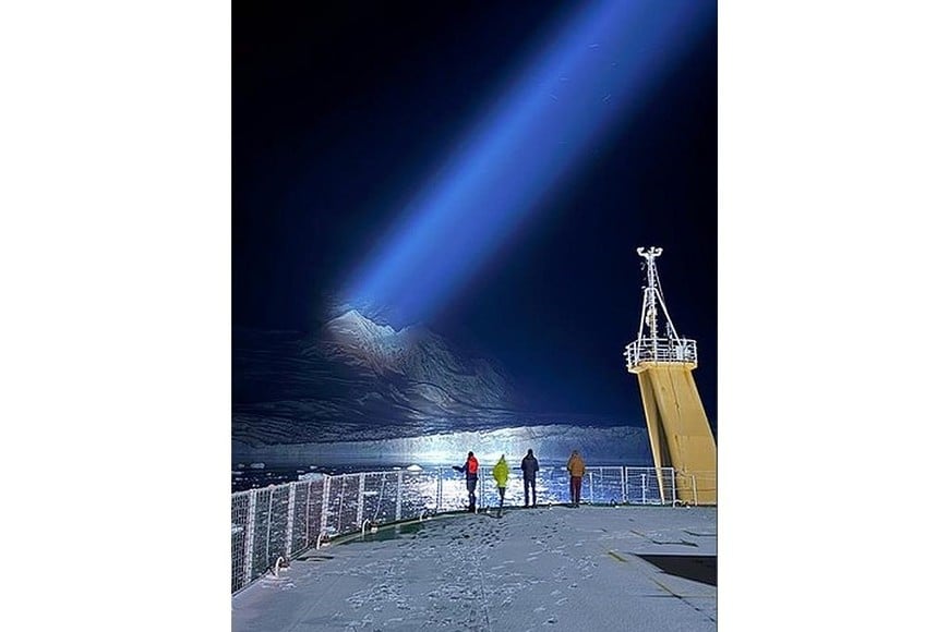 Los focos del buque un glaciar antártico en plena noche polar.