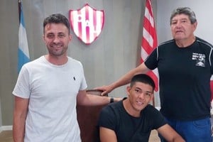 Cuando llegó al Tate. La firma de Diego Armando Díaz, junto a su repre y descubridor, en la sede tatengue. Foto: El Litoral.